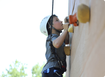 Camper rock climbing on a wall.