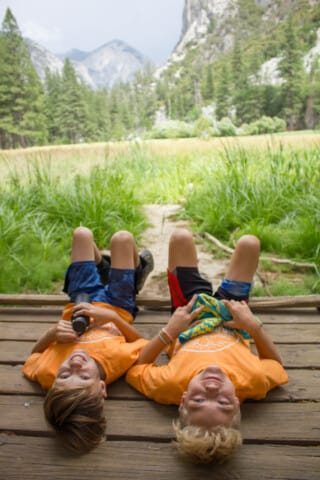 Two campers laying on a deck together.