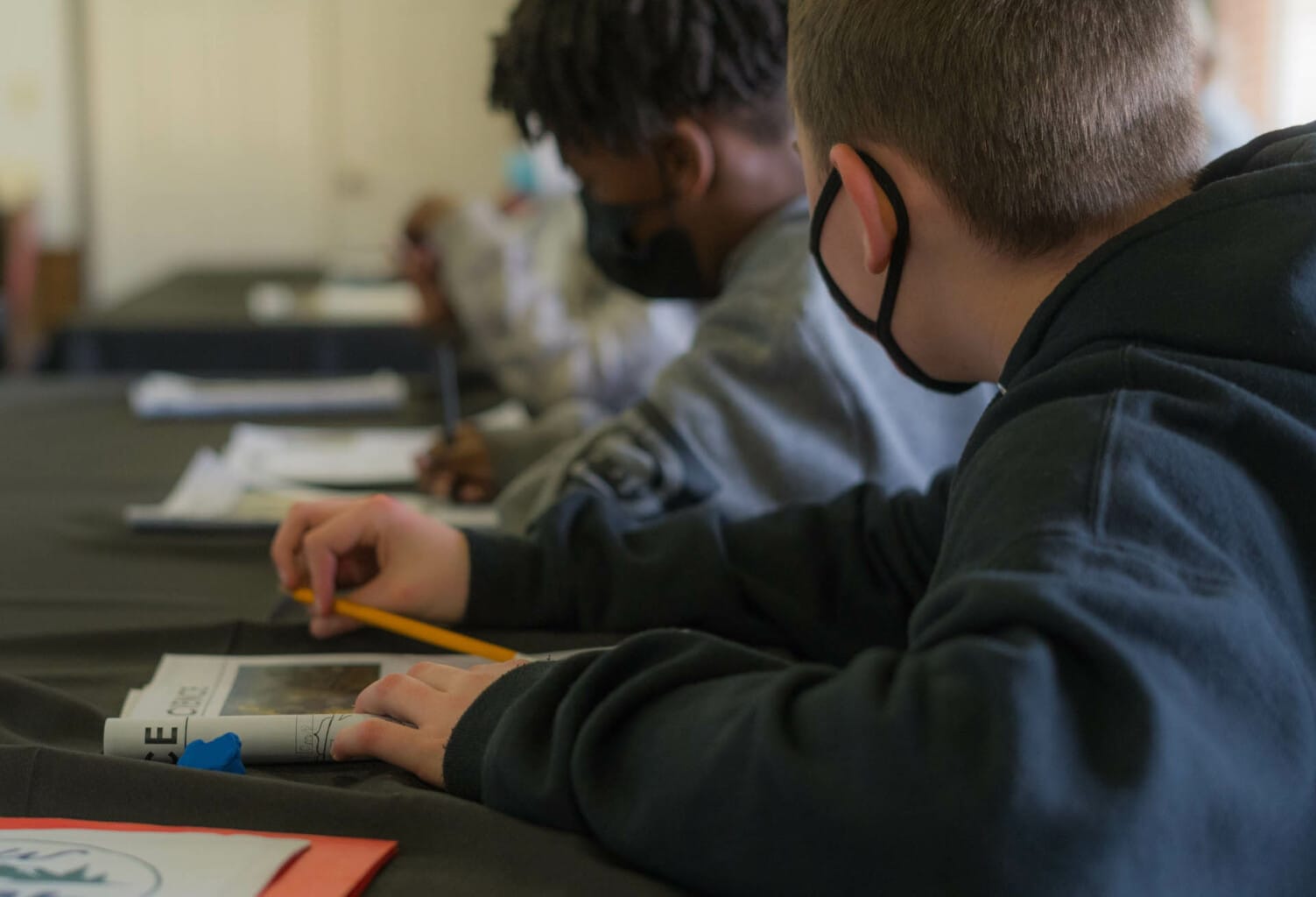 Campers working in workbooks.