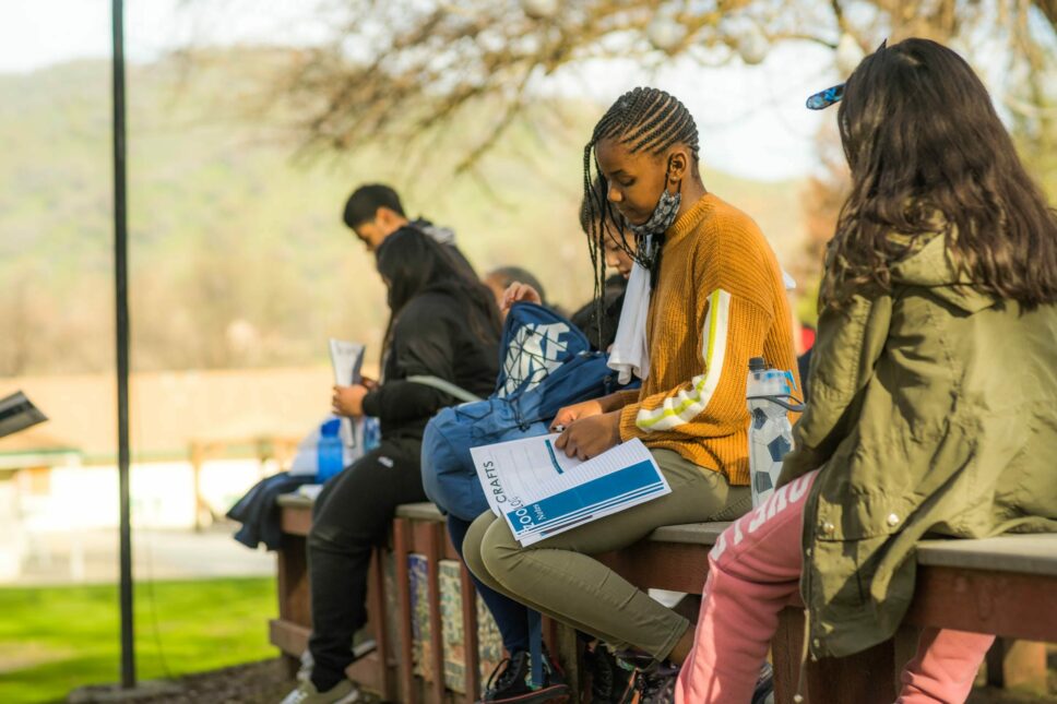 Campers writing in their notebooks.