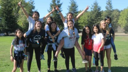 Group of campers taking a fun group photo on the field.