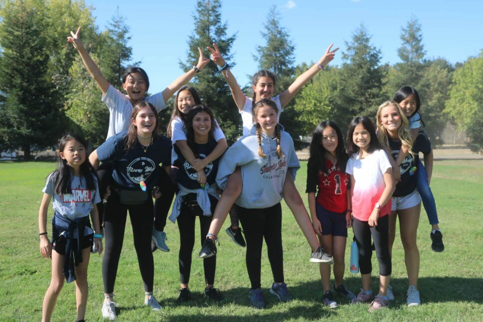 Group of campers taking a fun group photo on the field.