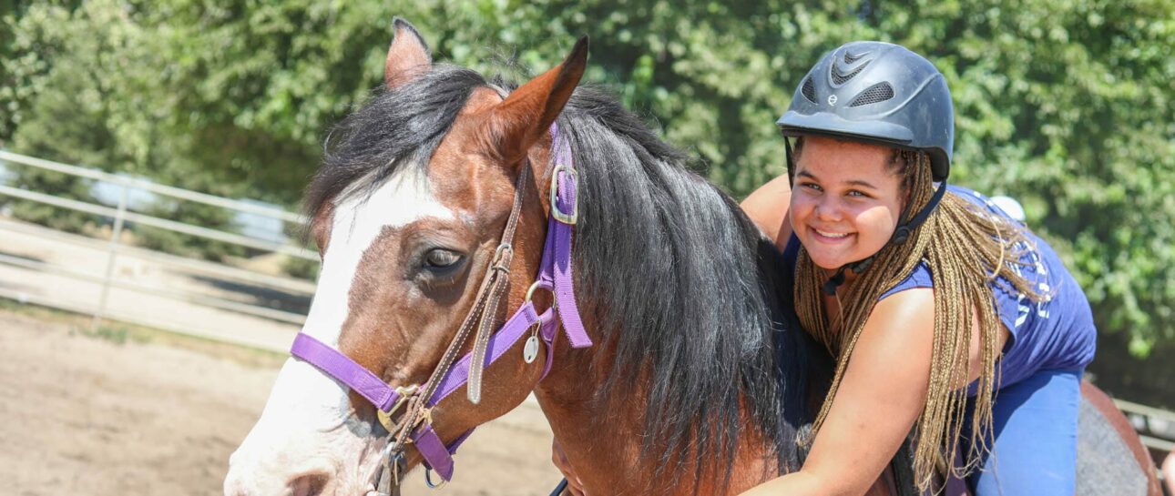 Camper smiling on a horse.