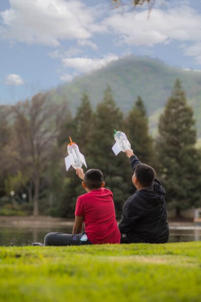 Two campers holding up their bottle rockets.