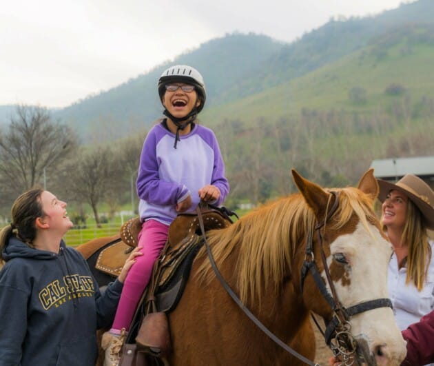 Girl laughing on horse.