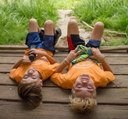 Two campers laying on a deck together.