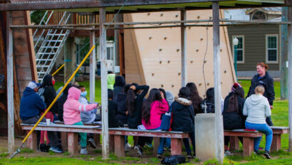 Students learning in a group how to build a raft
