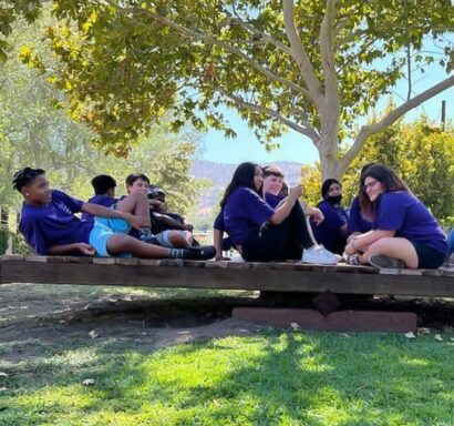 Kids sitting on seesaw.